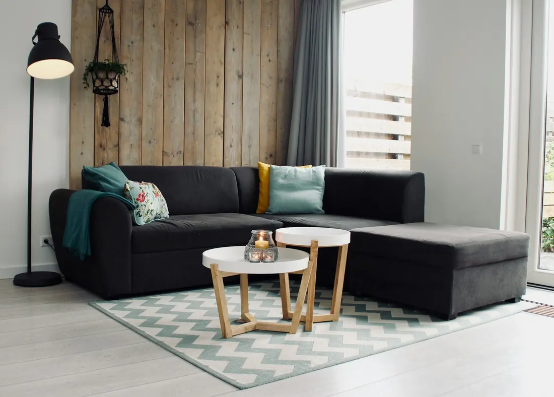Salon avec canapé d'angle et tapis à motifs